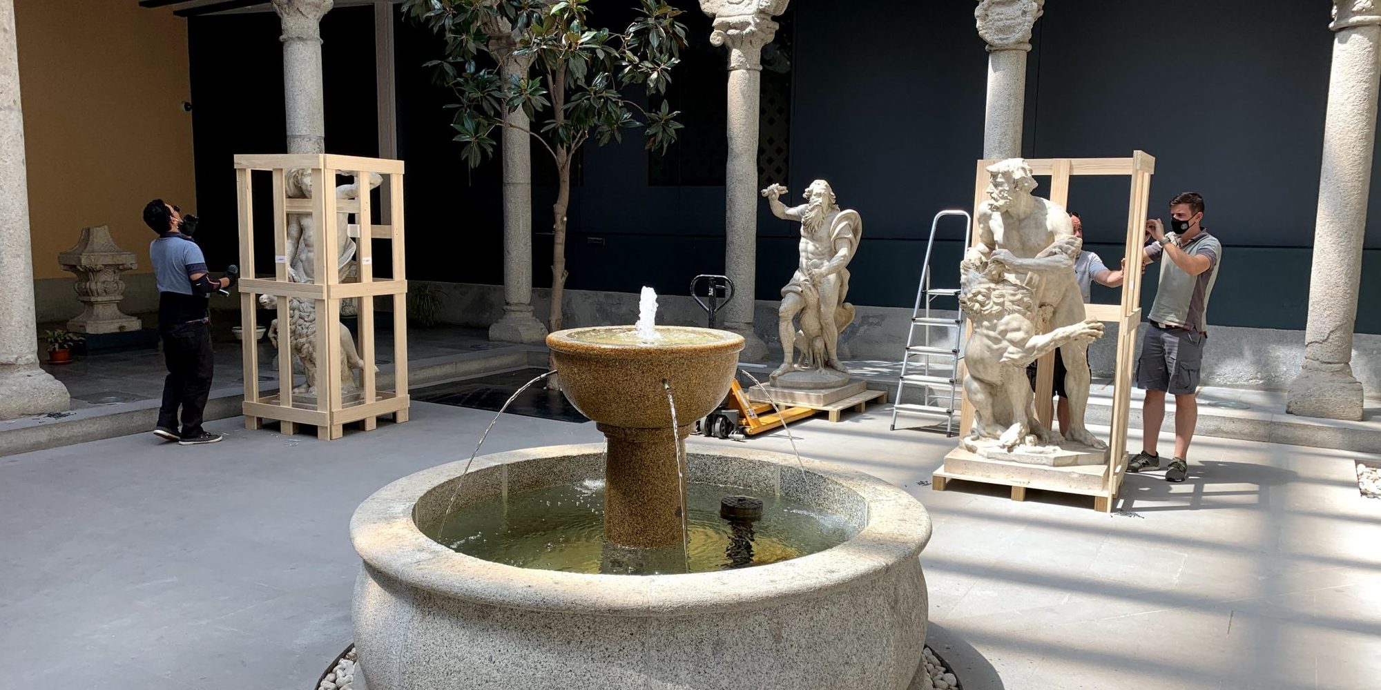 Esculturas de mármol embaladas en cajas de madera a medida en el patio de un museo, durante un traslado del equipo de WPAS